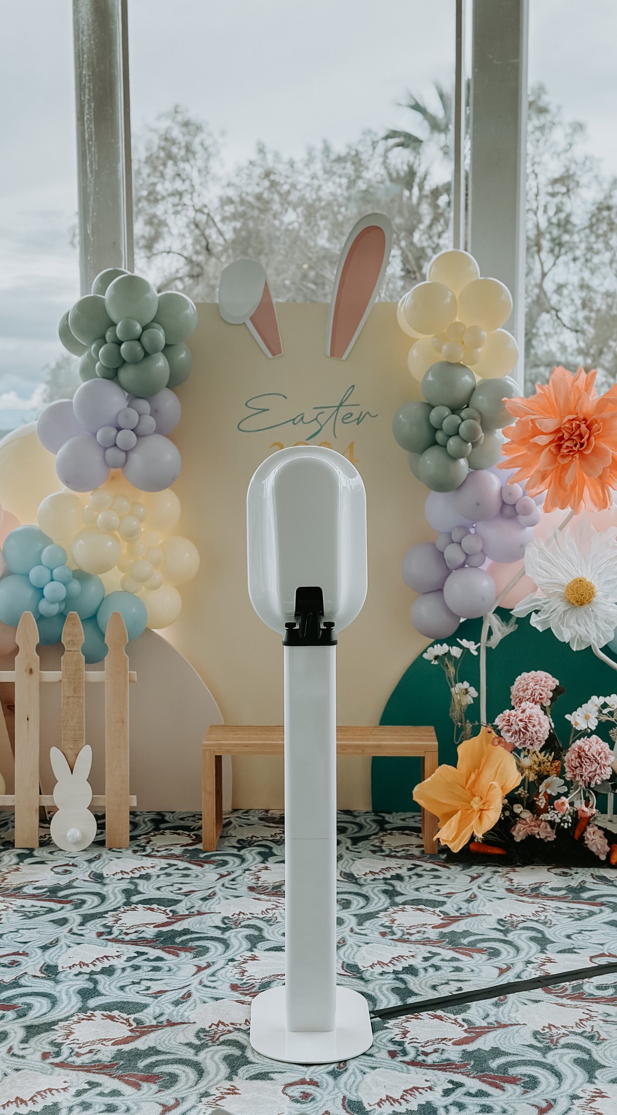 The booth beside a pastel balloon arch and spring florals