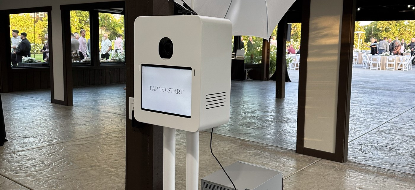 The booth and its umbrella light standing on the flat floor of an open timber framed venue