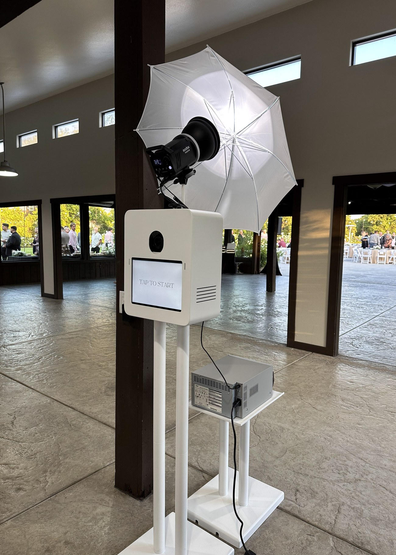 The photo booth beside a large umbrella softbox set up inside a venue