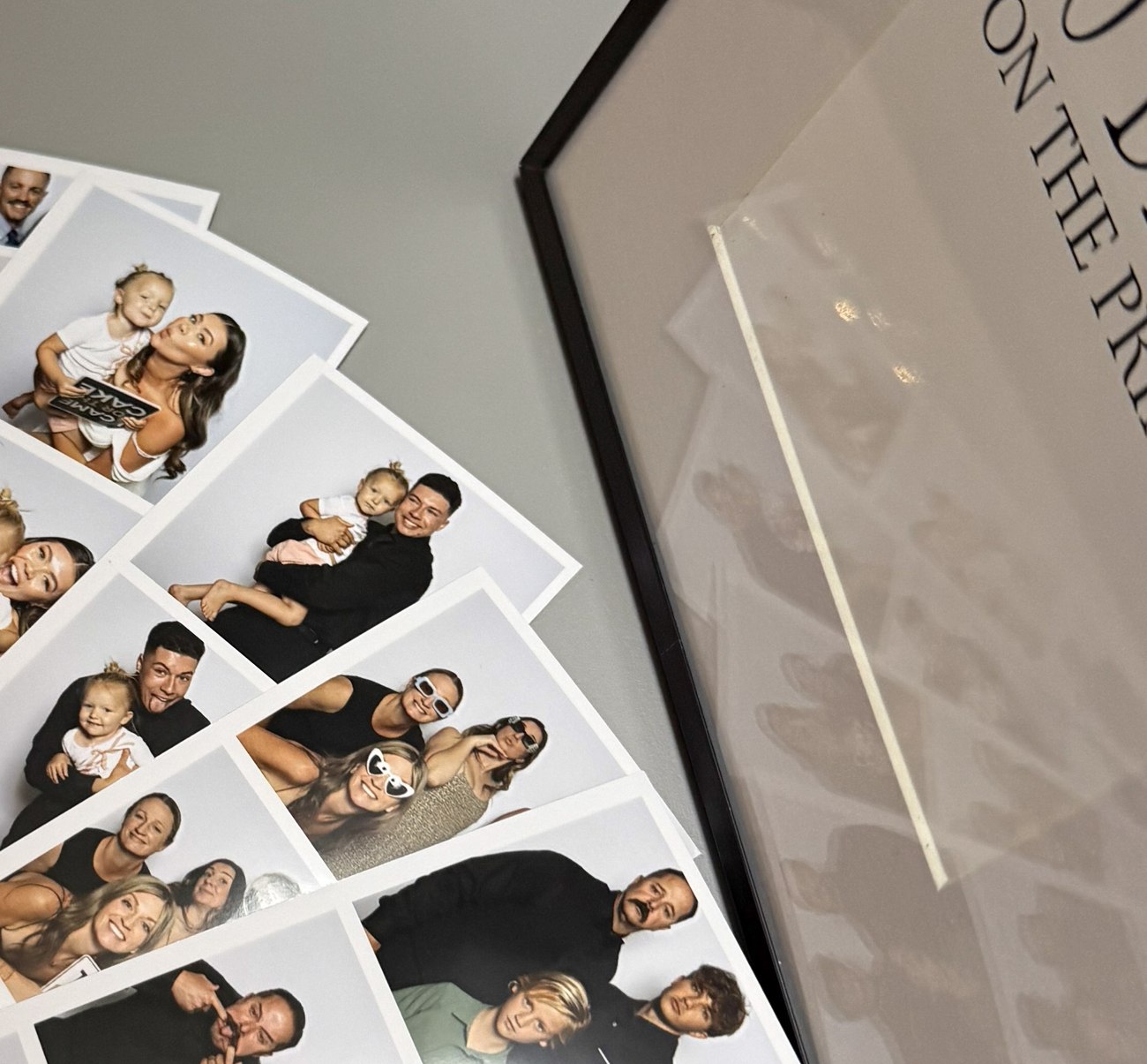 Printed photo strips fanned out on a table at a reception