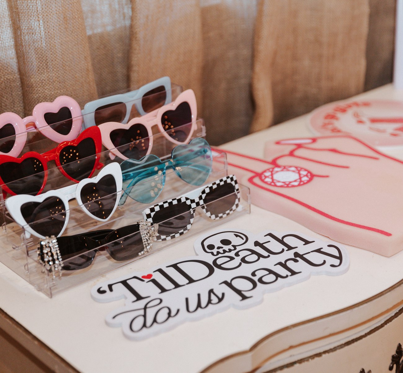 Heart shaped prop glasses beside a Til Death Do Us Party sign
